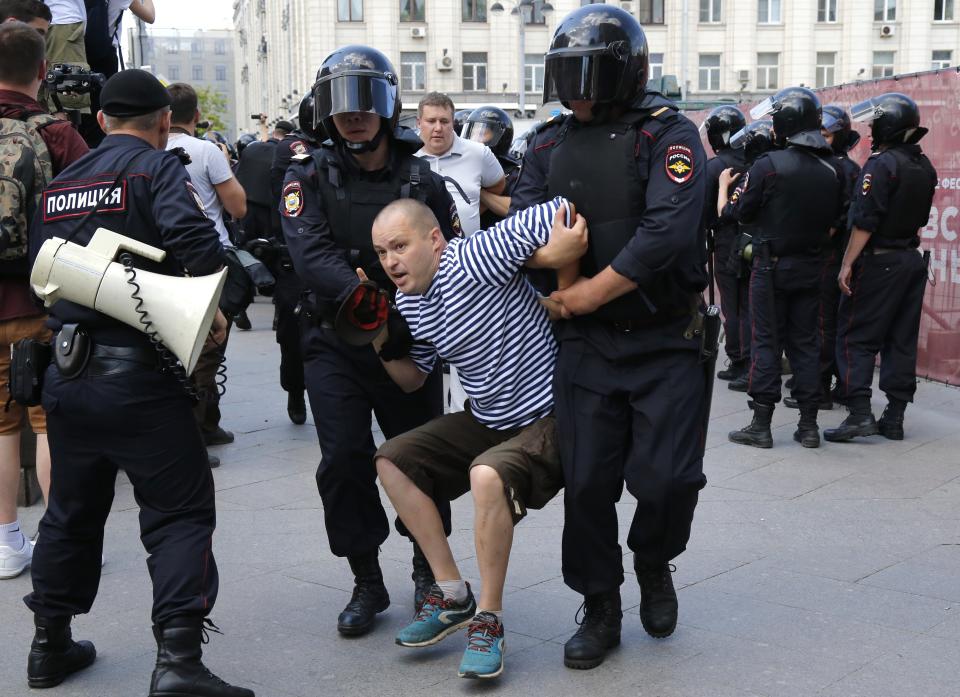 Police officers detain a man during an unsanctioned rally in the center of Moscow, Russia, Saturday, July 27, 2019. Russian police on Saturday began arresting people outside the Moscow mayor's office ahead of an election protest demanding that opposition candidates be allowed to run for the Moscow city council. (AP Photo/Alexander Zemlianichenko)