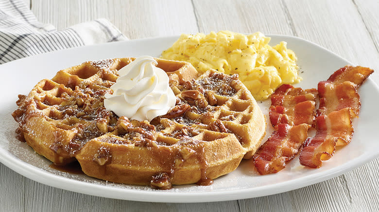 plate of waffle, eggs, and bacon