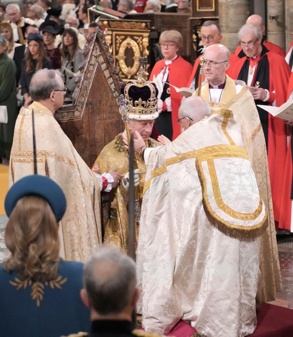 King Charles III sits as he is crowned with St. Edward's Crown by the Archbishop of Canterbury Justin Welby during the coronation ceremony at Westminster Abbey, London, Saturday, May 6, 2023.