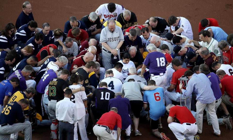 Members of the Republican and Democratic congressional baseball teams gather for a bipartisan prayer before the start of the game.