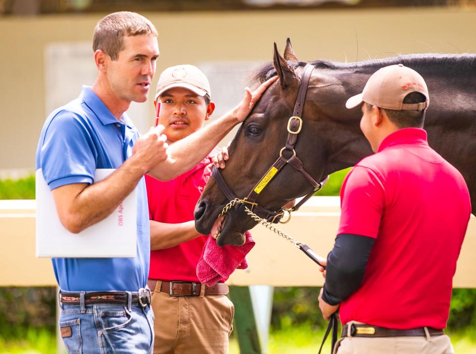 Tristan de Meric, left, talks with Groom Victor Hernandez, center, and Showman Kevin Mandojado before Hip #401, a colt by Medaglia d'Ora out of Eltimaas, went into the auction ring last week.