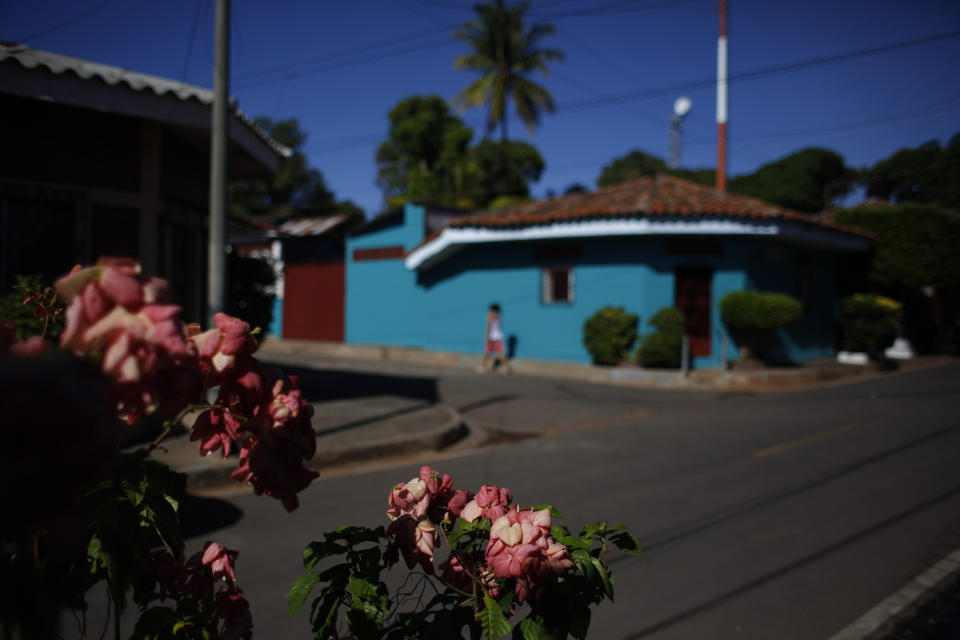 In this Aug. 18, 2018 photo, flowers grow along a residential street in Intipuca, El Salvador. While many Salvadoran communities are torn by violence, Intipuca is calm and safe. (AP Photo/Rebecca Blackwell)