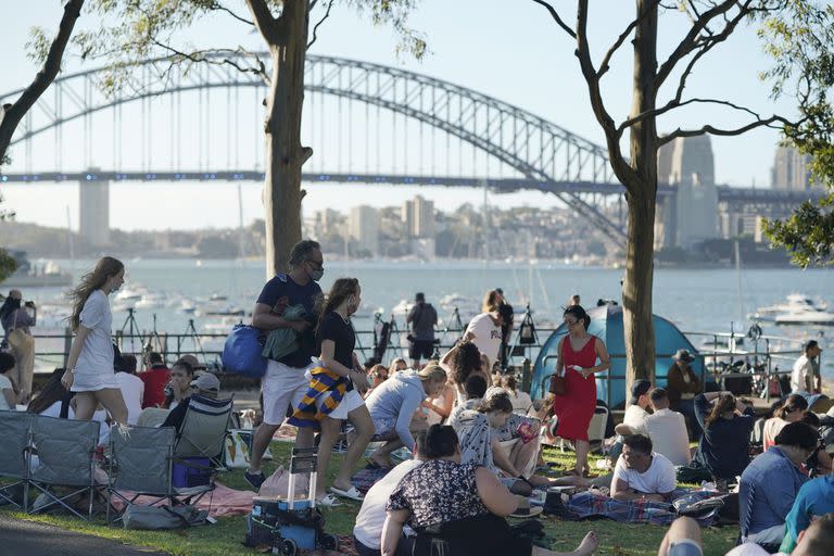 La gente se reúne frente al Sydney Harbour Bridge, antes de los fuegos artificiales de Nochevieja en Sidney, Australia, el viernes 31 de diciembre de 2021