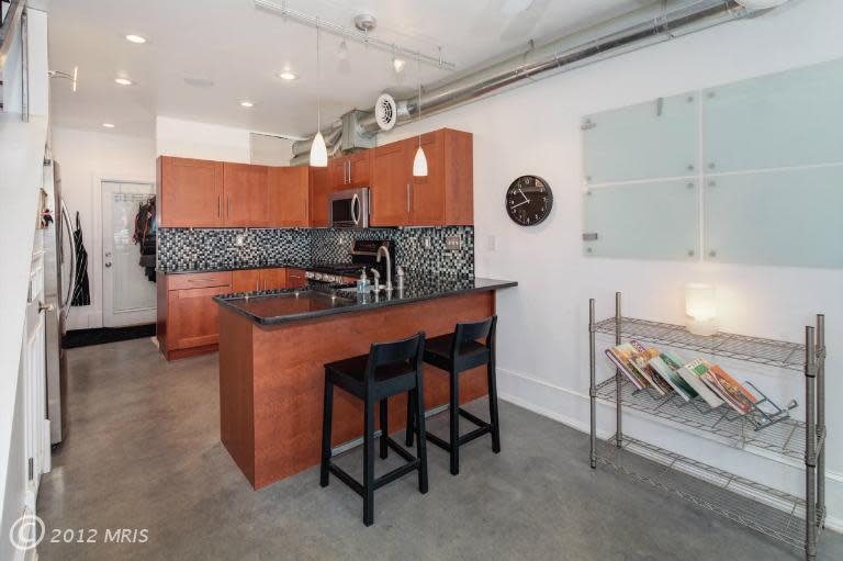 The kitchen counter divides the room into discrete zones for cooking and eating. Next photos: Two more broad views of the kitchen.