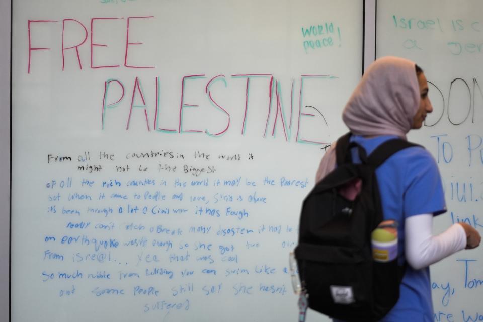 Tasneem Nada walks past a board on the campus of IUPUI, Wednesday, Feb. 7, 2024, in Indianapolis. The heart of most opposition leveled against the bill from pro-Palestinian and anti-Israel voices. State senators passed the amended version of the bill Tuesday in a 42-6 vote. But it needs final approval from the House, where the bill originated, before becoming law. (AP Photo/Darron Cummings)