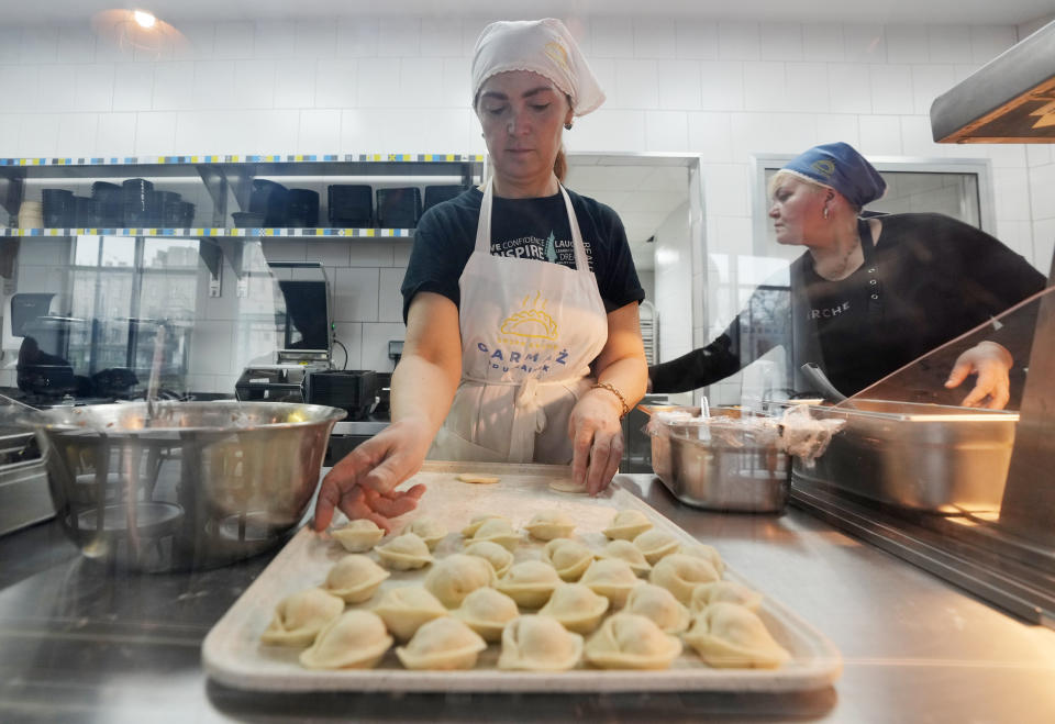 Ukrainian refugee women working at a Ukrainian food bar that a private foundation has opened to offer jobs to the refugees, in Warsaw, Poland, on Friday, April 1, 2022. Having escaped from Russian shelling, Ukrainian refugees are now focused on building new lives — temporarily or permanently. Countries neighboring their homeland, like Poland and Romania, are sparing no effort to help them integrate and feel needed in the new environment. (AP Photo/Czarek Sokolowski)