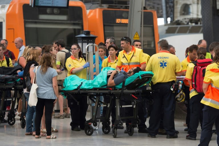 Emergency personnel help the injured after a commuter train hit the end of a platform at Barcelona's Francia station on July 28, 2017