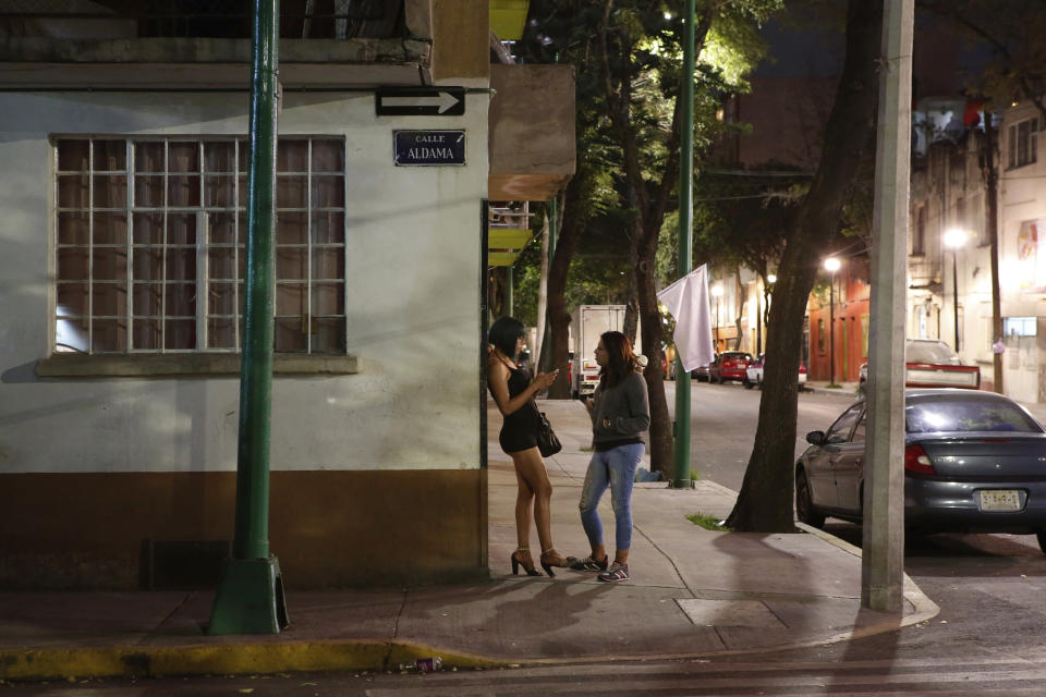 In this Aug. 28, 2019 photo, trans rights activist Kenya Cuevas talks with Italia, a 24-year-old transgender sex worker from the state of Oaxaca, on a street corner in Mexico City. Cuevas' origin story as an activist who demands protections for trans women dates back to Sept. 29, 2016. That was the night her friend and fellow trans sex worker got into a client's Nissan compact car and was shot multiple times. (AP Photo/Ginnette Riquelme)