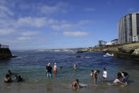 Visitors line an iconic beach at the La Jolla Friday, June 17, 2022, in San Diego. The summer of 2022 can feel as if the coronavirus pandemic is really over, as tourists flock to the area's famous beaches. (AP Photo/Gregory Bull)