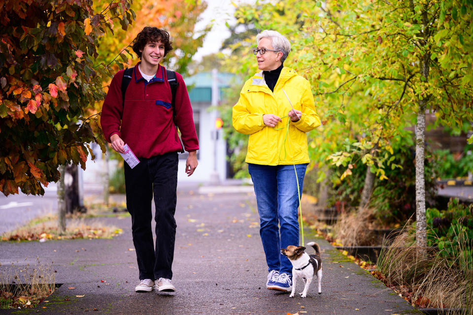 Democratic gubernatorial nominee Tina Kotek, right, and her dog, Teddy, walk with Oscar Ponteri of Teens for Tina during a media appearance before casting their early ballots on Nov. 2, 2022, in Portland, Oregon.