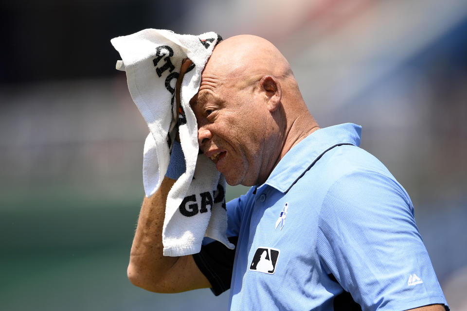 First base umpire Kerwin Danley wipes his head with a towel before the fifth inning of a baseball game between the Washington Nationals and the New York Mets, Sunday, June 20, 2021, in Washington. (AP Photo/Nick Wass)