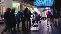 Passers-by in Times Square interact with a Promobot robot that informs the public about the symptoms of coronavirus and how to prevent it from spreading, in this still frame obtained from video, in New York City