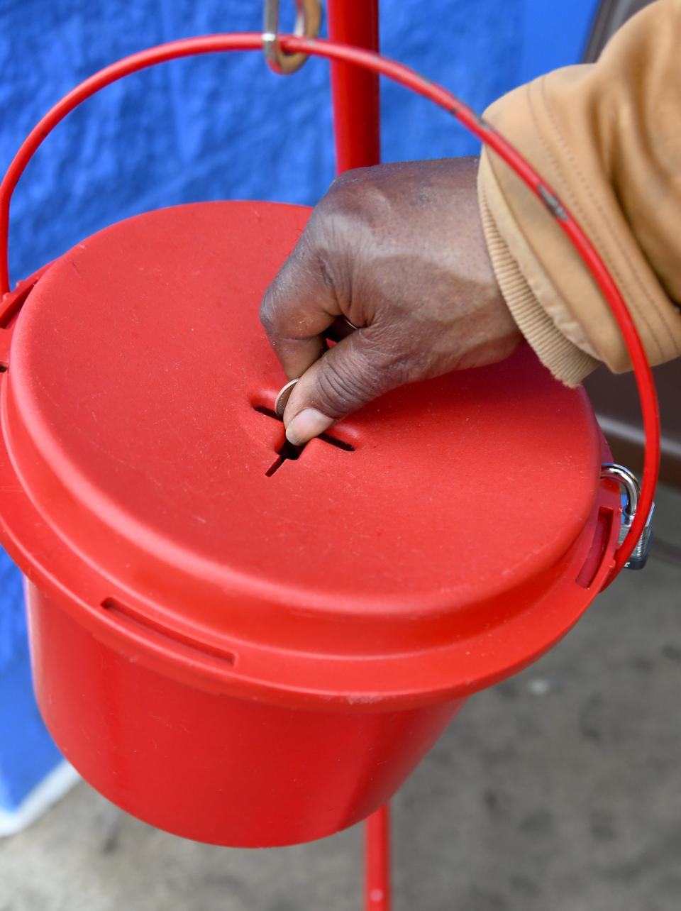 A visitor drops change into a Salvation Army kettle on Wednesday outside the Walmart store on Atlantic Boulevard in Canton.