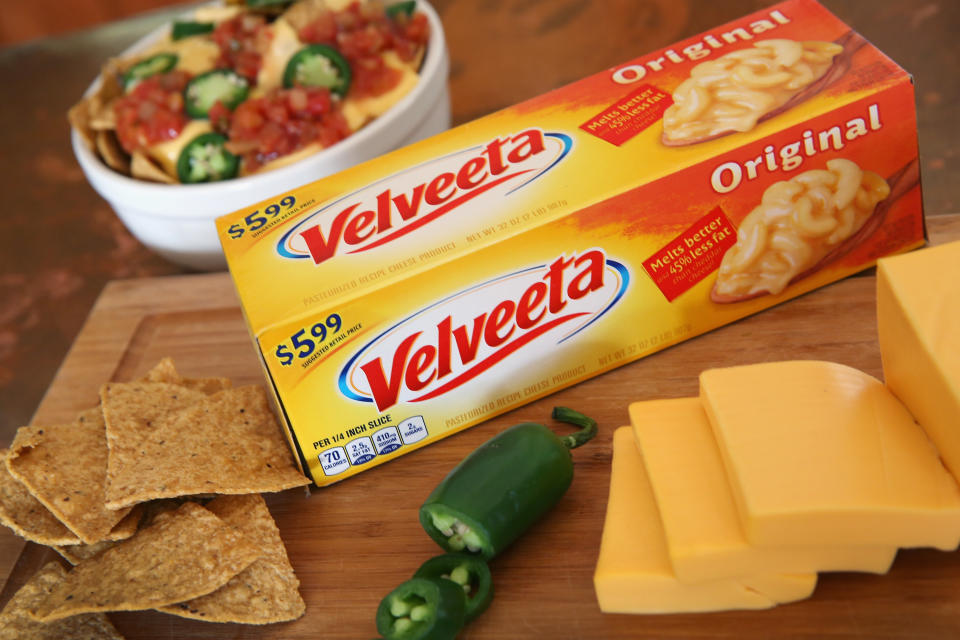 Velveeta on a cutting board with jalapenos and chips