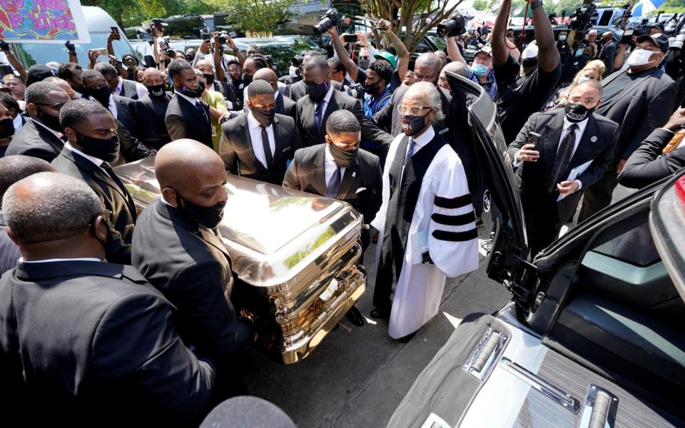 The Funeral home team pushes the casket of George Floyd into the hearse as the Rev. Al Sharpton (right) looks on after the funeral service for George Floyd at the Fountain of Praise church, in Houston - Reuters