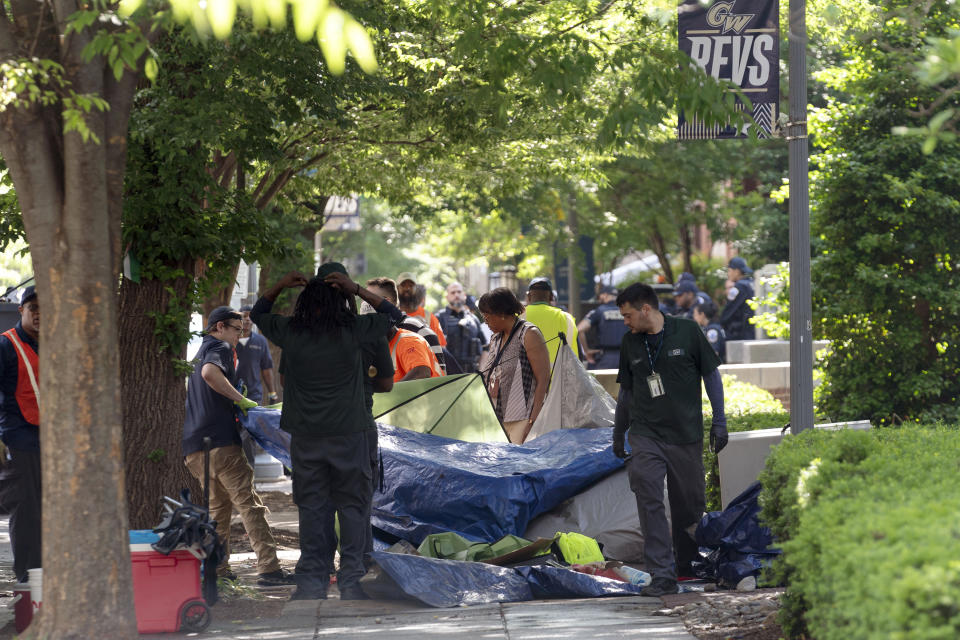 Workers carry student tents to a dump truck after police cleared a pro-Palestinian tent encampment at George Washington University early Wednesday and arrested demonstrators, Wednesday, May 8, 2024, in Washington. (AP Photo/Jose Luis Magana)