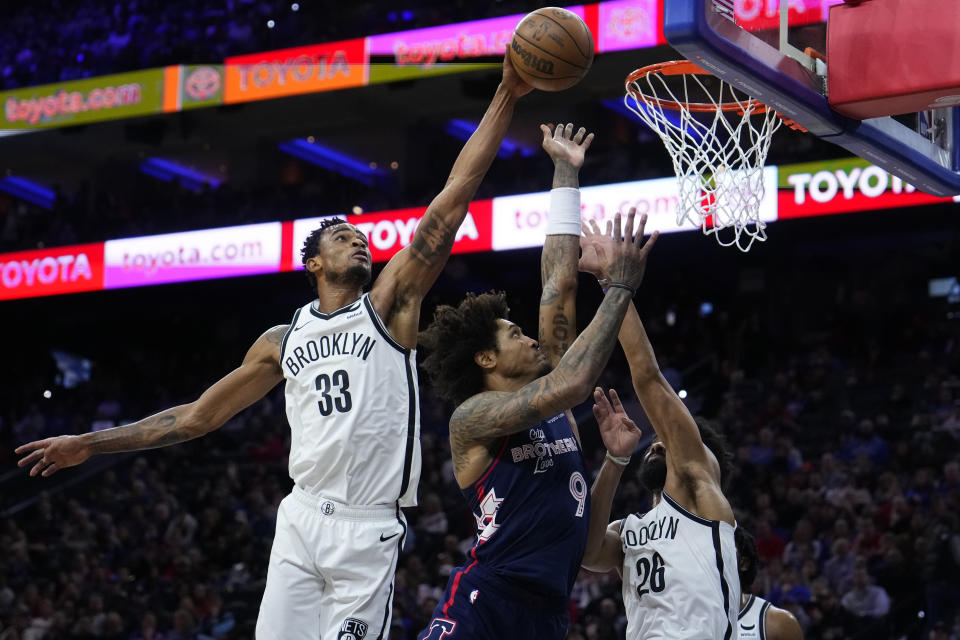 Philadelphia 76ers' Kelly Oubre Jr., center, goes up for a shot against Brooklyn Nets' Spencer Dinwiddie, right, and Nic Claxton during the first half of an NBA basketball game, Saturday, Feb. 3, 2024, in Philadelphia. (AP Photo/Matt Slocum)