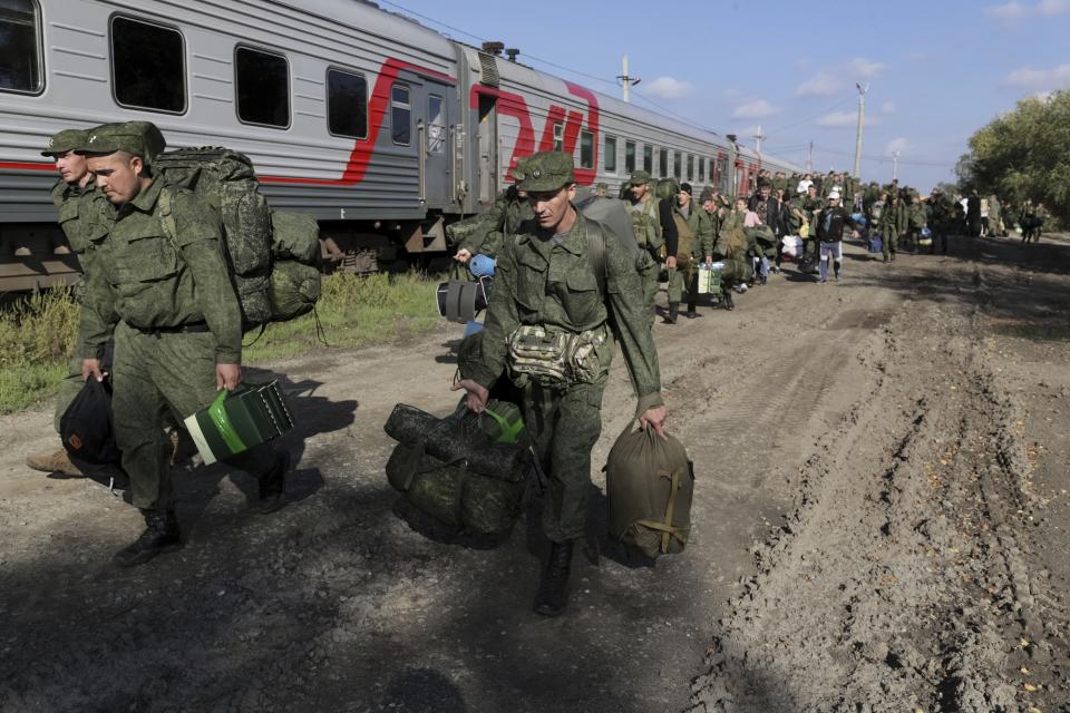 FILE - Russian recruits walk to take a train at a railway station in Prudboi, Volgograd region of Russia, on Sept. 29, 2022. Eight months after Russian President Vladimir Putin launched an invasion against Ukraine expecting a lightening victory, the war continues, affecting not just Ukraine but also exacerbating death and tension in Russia among its own citizens. (AP Photo, File)