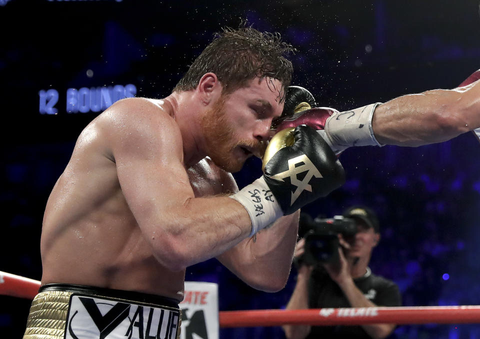 Canelo Alvarez takes a punch from Gennady Golovkin in the 10th round during a middleweight title boxing match, Saturday, Sept. 15, 2018, in Las Vegas. (AP Photo/Isaac Brekken)
