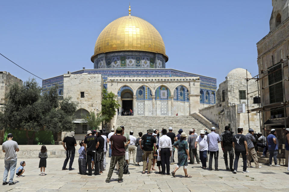 Israeli Jewish men stand at the steps leading to the Dome of the Rock Mosque in the Al Aqsa Mosque compound, during the annual mourning ritual of Tisha B'Av (the ninth of Av) -- a day of fasting and a memorial day, commemorating the destruction of ancient Jerusalem temples, in the Old City of Jerusalem, Sunday, July 18, 2021. (AP Photo/Mahmoud Illean)