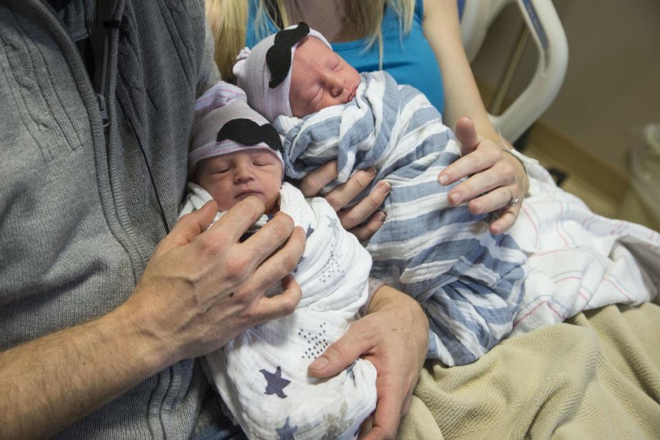 In a Jan. 1, 2017 photo, Brandon Shay, and his wife Holly of Glendale, Ariz., hold their new born twins at at Banner Hospital in Glendale. The couple welcomed their first son, Sawyer, right, into the world at 11:51 p.m. Saturday. Their second son, Everett, arrived one minute after midnight on Sunday. (Nick Oza/The Arizona Republic via AP)