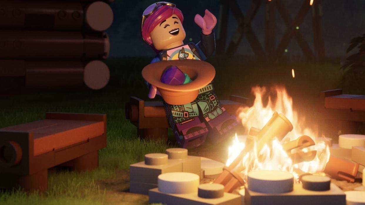  A Lego character sitting by a campfire. They are laughing and throwing their head back, while holding a bowl of food. 