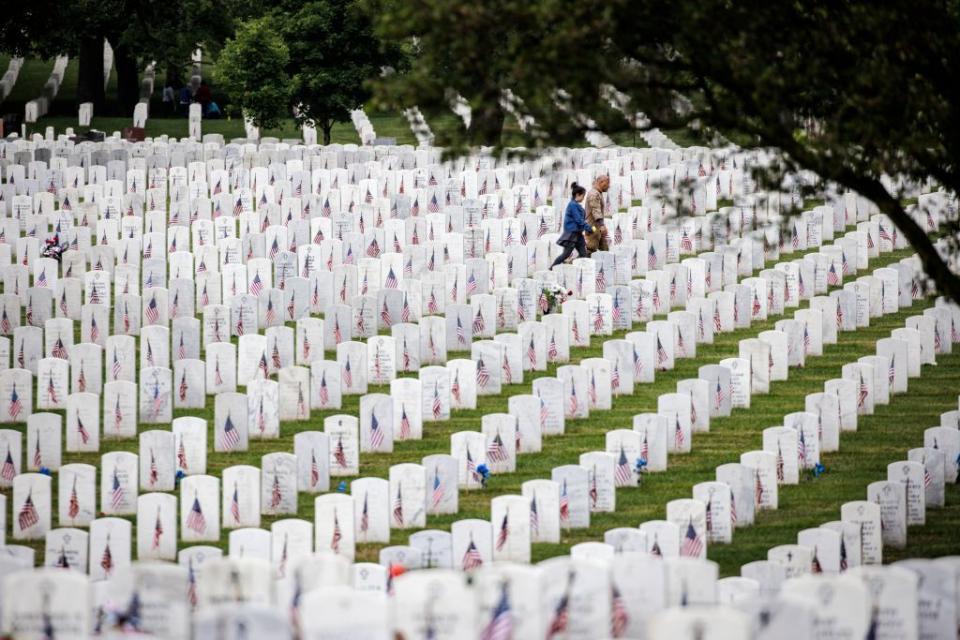 Visitors walk through the rolling hills of headstones marking the final resting place of service men and women in Arlington National Cemetery.