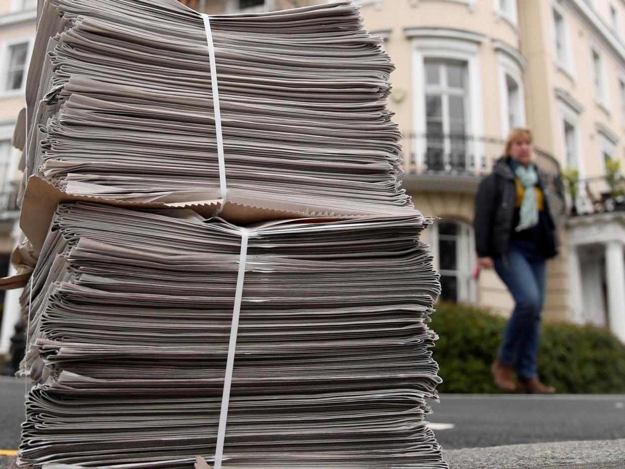 A pile of newspapers are seen on a pavement awaiting delivery to homes in London as the spread of the coronavirus continues: REUTERS