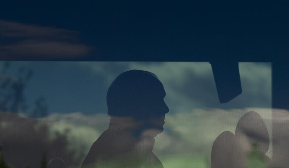 NDP Leader John Horgan is silhouetted as he sits on his campaign bus following an announcement during a election campaign stop in North Vancouver, British Columbia, Tuesday, Sept. 22, 2020. (Jonathan Hayward/The Canadian Press via AP)