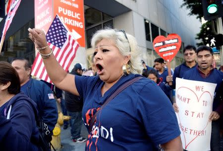 Protesters hold up signs during a march and rally against the United States President-elect Donald Trump in Los Angeles, California, U.S. December 18, 2016.REUTERS/Kevork Djansezian