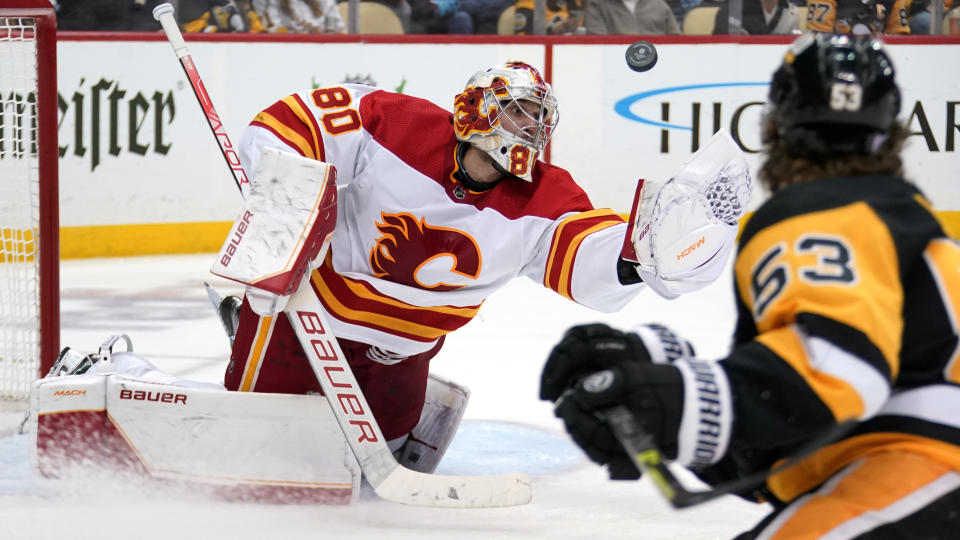 Calgary Flames goaltender Dan Vladar (80) reaches to glove the puck during the second period of the team's NHL hockey game against the Pittsburgh Penguins in Pittsburgh, Wednesday, Nov. 23, 2022. (AP Photo/Gene J. Puskar)