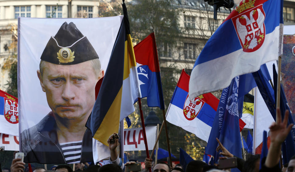 In this Saturday, Nov. 15, 2014 file photo, a supporter of Serbian ultranationalist leader Vojislav Seselj holds a picture of Russian President Vladimir Putin during a protest In Belgrade, Serbia. Vladimir Putin has accused the U.S. and the West of destabilizing the Balkans with NATO expansion policies as Serbia prepares a hero's welcome for the Russian president. (AP Photo/Darko Vojinovic, File)