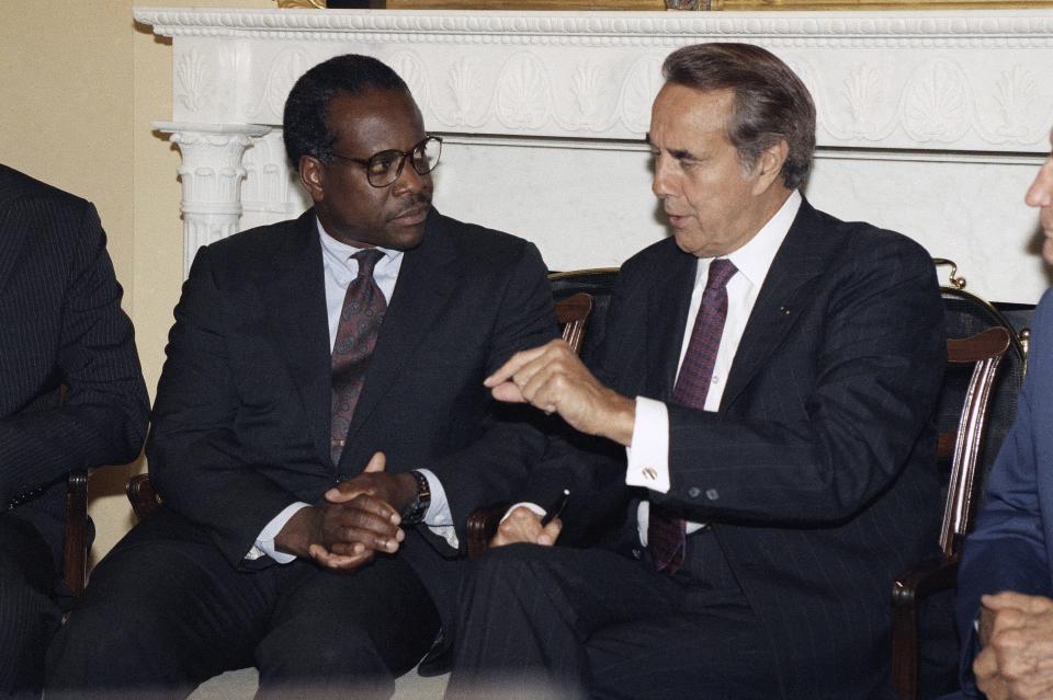 Judge Clarence Thomas confers with Senate Minority Leader Robert Dole (R-Kansas), at the Capitol in Washington, July 8, 1991. Thomas has been nominated by President Bush to be an associate justice of the Supreme Court. 