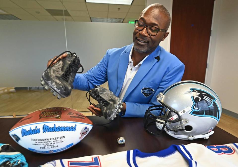 Former Carolina Panthers wide receiver Muhsin Muhammad holds a pair of cleats he wore for an entire season. His kids would repaint them and he would tape them following each game to ensure their longevity.