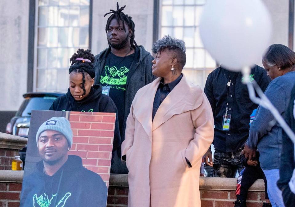 During a Day of Remembrance for Gun-Related Homicide Victims ceremony in Durham Friday, Dec. 30, 2022, gun violence prevention advocates from Bull City United, from left, Latisha Williamson, Mario Melvin and Keshia Gray stand with a photograph of Reshaun Cates who was found shot to death in his car off Interstate 85 near Hillandale Road in October.