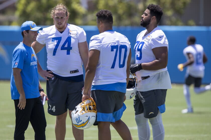 Los Angeles Chargers head coach Brandon Staley, left, talks with offensive tackles Storm Norton.