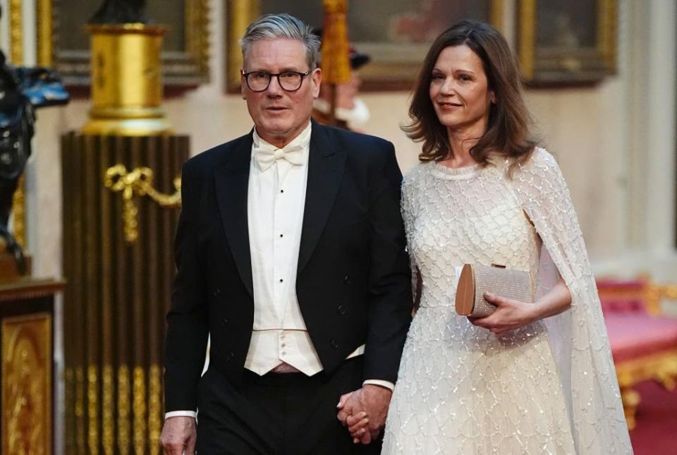 labour leader sir keir starmer with his wife victoria make their way along the east gallery to attend a state banquet at buckingham palace