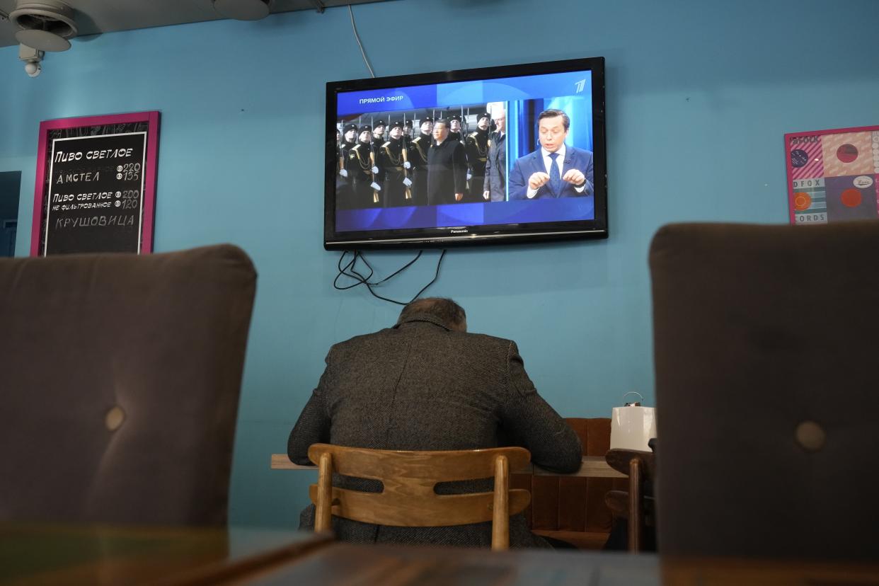 A TV screen displays Chinese President Xi Jinping attending an official welcome ceremony upon his arrival at the Vnukovo-2 government airport outside Moscow, in a cafe in St. Petersburg, Russia, Monday, March 20, 2023. (AP Photo)