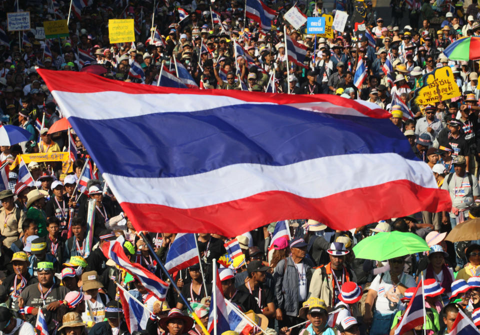 Anti-government protesters with national flags gather for a rally Monday, Jan. 13, 2014, in Bangkok, Thailand. Anti-government protesters took over key intersections in Thailand's capital Monday, halting much of the traffic into Bangkok's central business district as part of a months-long campaign to thwart elections and overthrow the democratically elected prime minister.(AP Photo/Sakchai Lalit)