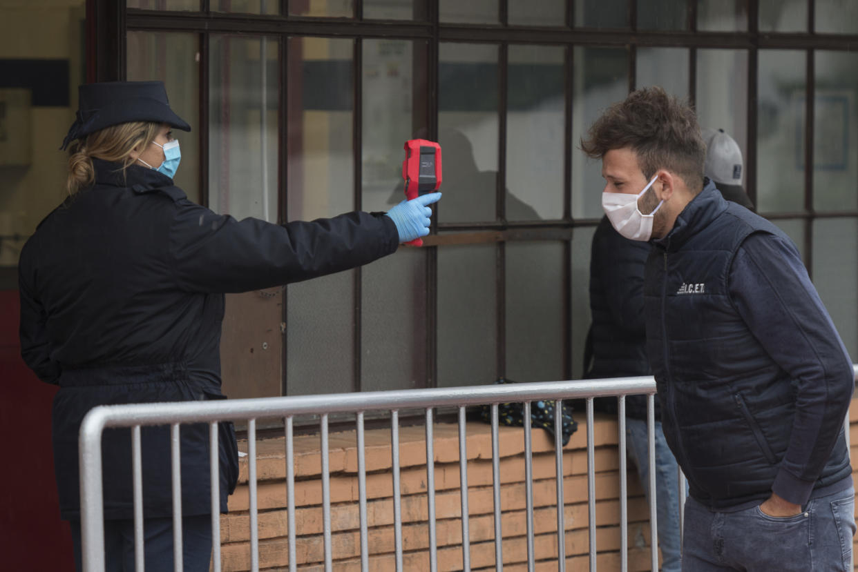 TURIN, ITALY - APRIL 28: An FCA security agent scans the body temperature of an employee of Italian automobile manufacturer FCA on April 28, 2020 in Turin, Italy. The FCA Mirafiori plant in Turin resumes production after the government during the Italian blockade aimed at taming the spread of the Coronavirus / COVID-19 infection had closed all the large companies. Italy will remain on lockdown to stem the transmission of the Coronavirus (Covid-19), slowly easing restrictions. (Photo by Stefano Guidi/Getty Images)