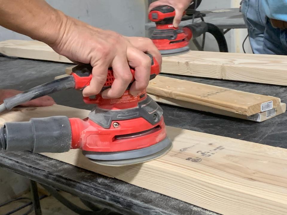 Volunteers with Sleep in Heavenly Peace sand wood to be used on bed frames on Nov. 23, 2021.