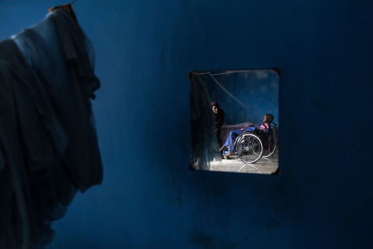 Un niño junto a su cuidador en Cheshire Home en Freetown, Sierra Leona. Los niños discapacitados en Freetown a menudo se quedan en la calle o se los considera indignos de recibir educación.