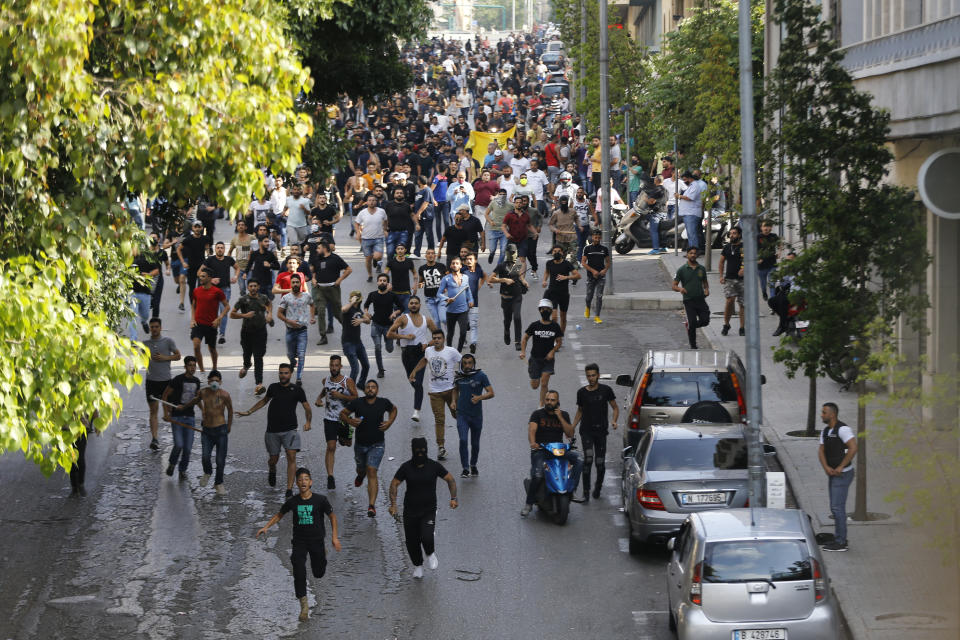 Shiite Hezbollah and Amal Movement groups run as they shout slogans against anti-government protesters, in downtown Beirut, Lebanon, Saturday, June 6, 2020. Hundreds of Lebanese demonstrators gathered in central Beirut Saturday, hoping to reboot nationwide anti-government protests that began late last year amid an unprecedented economic and financial crisis. (AP Photo/Bilal Hussein)