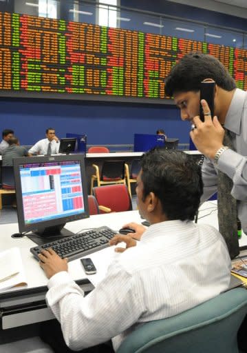 Share traders monitor prices at the Colombo Stock Exchange. Market regulator Tilak Karunaratne quit on August 17, saying he could no longer battle against a "mafia of crooks" preventing probes into insider trading and "pump-and-dump" scams in which investors drive up shares and then sell them