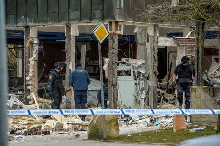 FILE PHOTO: Police officers stand at the scene of an explosion after what is believed to have been a robbery attempt on an ATM, in Genarp, southern Sweden March 21, 2016. REUTERS/Johan Nilsson/TT News Agency/File Photo