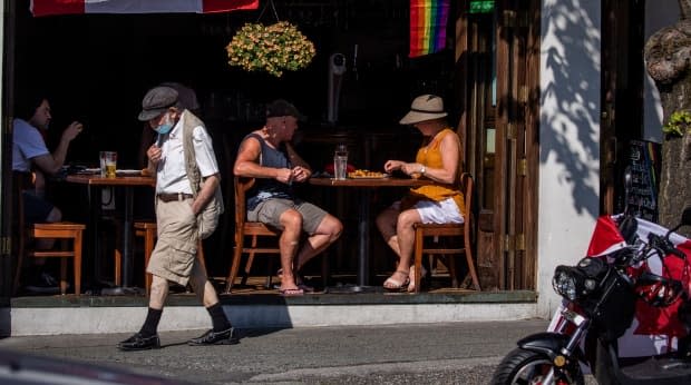 A group of people eat in a restaurant in Vancouver on July 1. Beginning next month, proof of vaccination will be required for patio and indoor dining. (Ben Nelms/CBC - image credit)