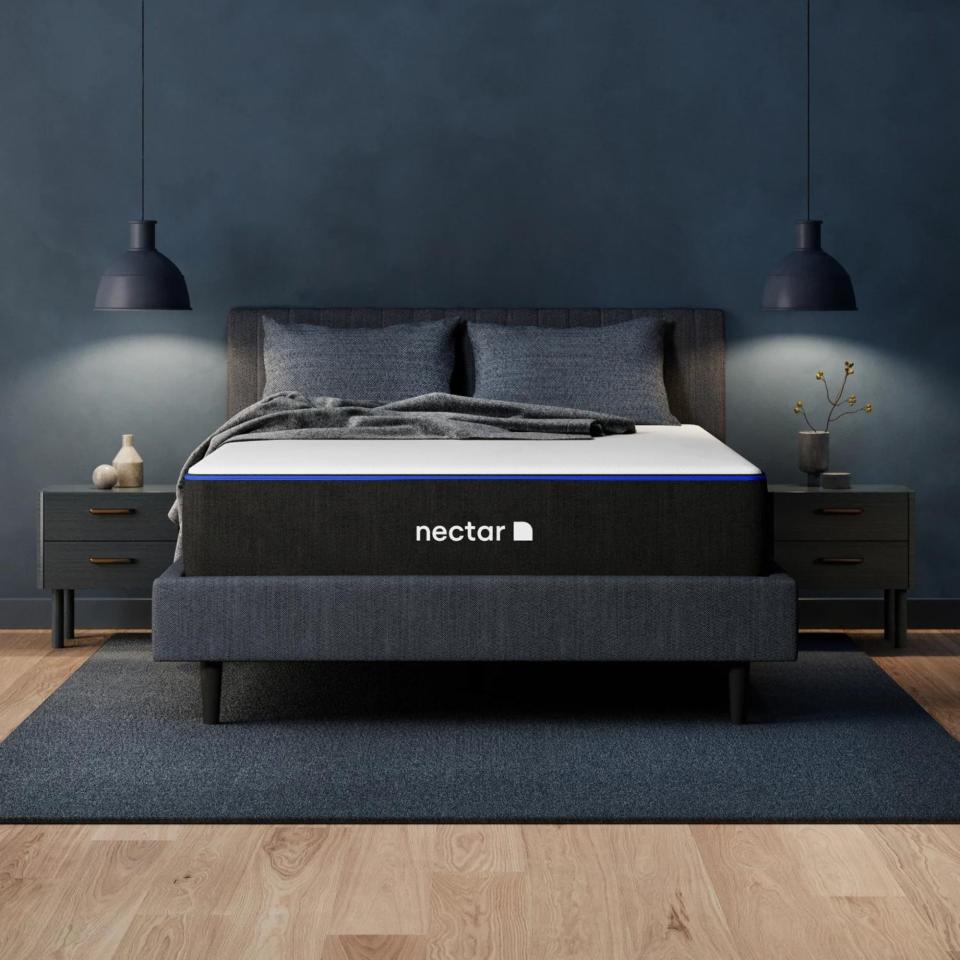 Nectar memory foam mattress on a bed against a dark wall.