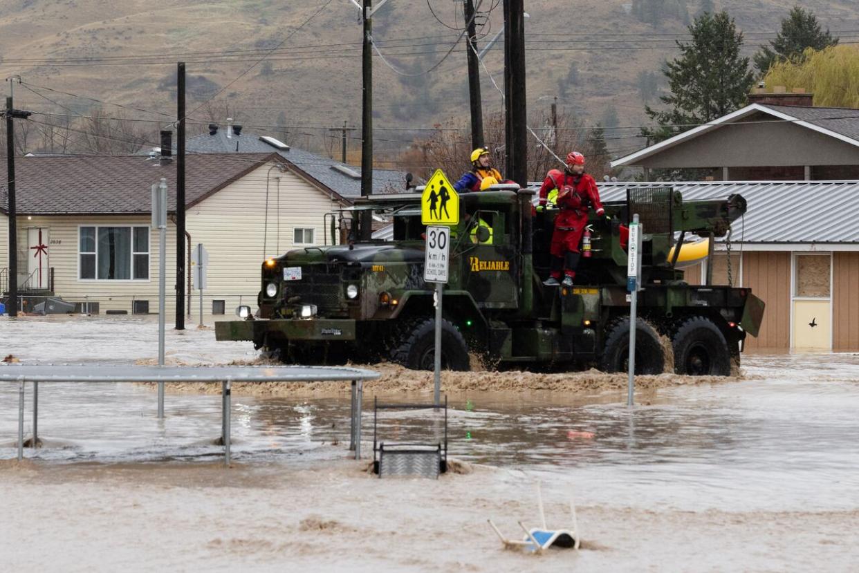 Emergency responders are pictured driving a truck through flooded streets in residential part of Merritt, B.C., on Nov. 15, 2021. (Maggie MacPherson/CBC - image credit)