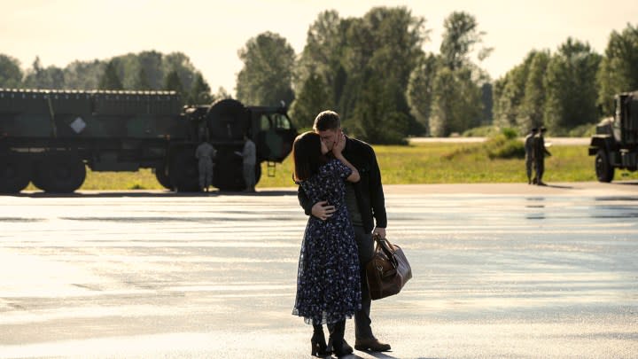 Peter and Rose kissing on the tarmac in a scene from The Night Agent.