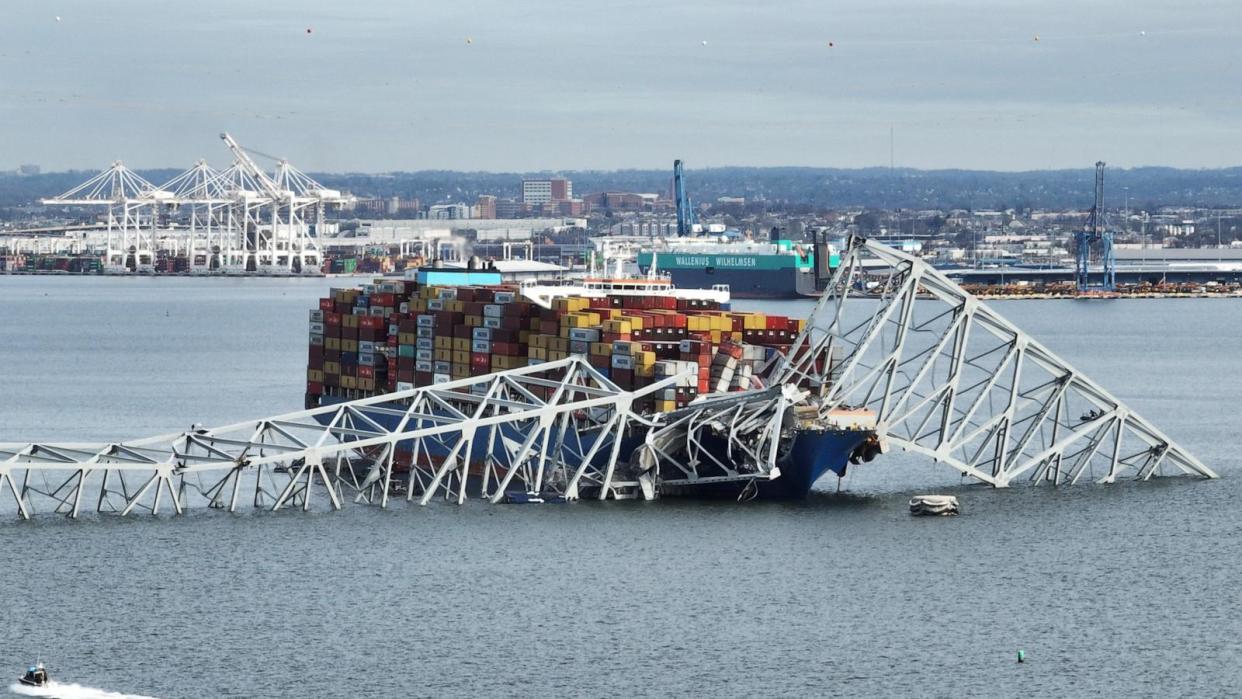 PHOTO:  In this aerial image, the steel frame of the Francis Scott Key Bridge sits on top of a container ship after the bridge collapsed, Baltimore, March 26, 2024. (Jim Watson/AFP via Getty Images)